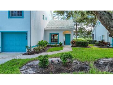 White condo with teal door and garage door at 6568 Fairway Gardens Dr, Bradenton, FL 34203