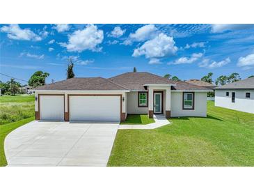 Newly built home with a two-car garage and well-manicured lawn at 16 Tee View Rd, Rotonda West, FL 33947