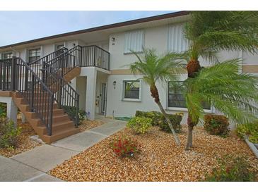Condo building with a stairway and landscaping at 26485 Rampart Blvd # D6, Punta Gorda, FL 33983