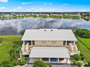 Aerial view of condo with lake view, two-car garage, and community at 26283 Nadir Rd # 201, Punta Gorda, FL 33983