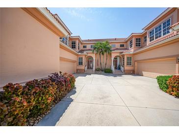 Three-story building with attached garages and lush landscaping at 3959 San Rocco Ct # 911, Punta Gorda, FL 33950