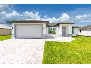 Modern single-story home with gray siding and a two-car garage at 2743 Hopwood Rd, North Port, FL 34287