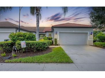 Villa with attached garage, landscaping, and driveway at 1289 Ballota Ln, North Port, FL 34289