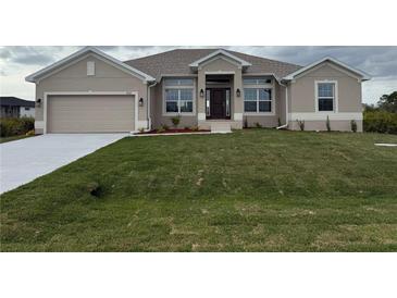 Charming single-story home featuring a well-maintained lawn, a two car garage, and stylish modern architecture at 8347 Ada St, Port Charlotte, FL 33981