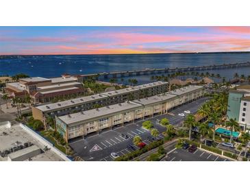 Aerial view of waterfront condo building with parking and nearby bridge at 150 Harborside Ave # 216, Punta Gorda, FL 33950