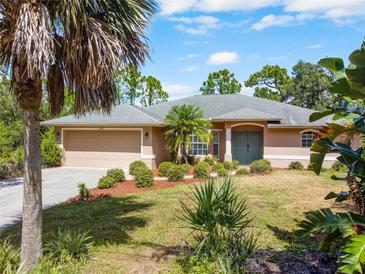 Single-story home with attached garage, landscaping, and a green door at 11786 De Miranda Ave, North Port, FL 34287