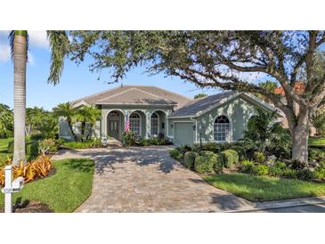 One-story home with tile roof, arched entryway, and landscaped yard at 3589 Pennyroyal Rd, Port Charlotte, FL 33953