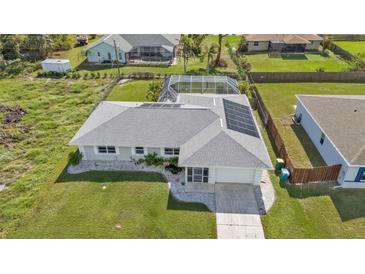 A captivating aerial view of a home featuring solar panels, screened-in lanai, and lush landscaping at 17341 Sabrina Cir, Port Charlotte, FL 33948