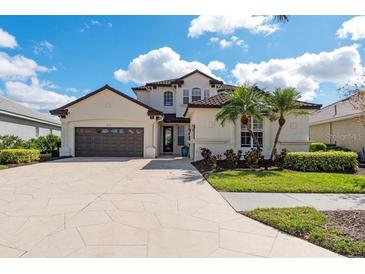 Beautiful two-story stucco home with tile roof, lush landscaping and a spacious driveway and two-car garage at 5241 Grand Palmetto Way, North Port, FL 34291