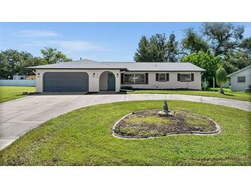 Charming single-story home with a spacious driveway and well-manicured lawn at 635 Erroll St, Port Charlotte, FL 33952