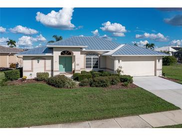 Single-story home with metal roof, light-colored exterior, and two-car garage at 3730 Turtle Dove Blvd, Punta Gorda, FL 33950