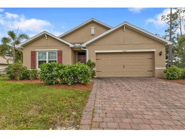 Tan one-story house with a red-brown door and brick driveway at 3640 Eagle Pass St, North Port, FL 34286