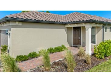 House exterior showing front entrance and walkway with landscaping at 1384 Raspberry Dr, North Port, FL 34289