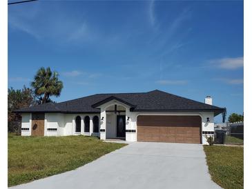 Newly built home with a brown garage door and landscaped lawn at 509 Clearview Dr, Port Charlotte, FL 33953