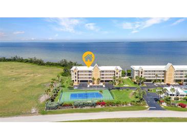 Beautiful waterfront condo complex with a tennis court and manicured landscaping at 101 N Marion Ct # 122, Punta Gorda, FL 33950
