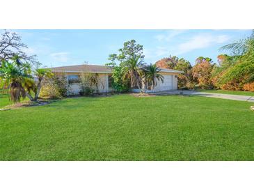 Ranch-style home with a spacious lawn and palm trees at 641 Colgate Rd, Venice, FL 34293