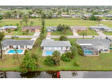 Bright aerial view of a charming single-Gathering home featuring a private backyard pool and lush landscaping at 25 Caddy Rd, Rotonda West, FL 33947