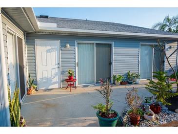 Back patio with potted plants and a white door at 3300 3300 # 3401, Punta Gorda, FL 33980