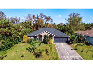 Charming single-story home with a well-maintained lawn, inviting curb appeal, and an attached two-car garage at 3316 Kacher Rd, North Port, FL 34288