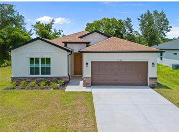 Inviting single-Gathering home with a two-car garage, tidy landscaping, and a charming facade, perfect for suburban living at 3390 Nadasky Ave, North Port, FL 34288