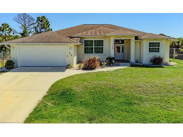 One-story home with attached garage and lush green lawn at 7116 Quigley St, Englewood, FL 34224