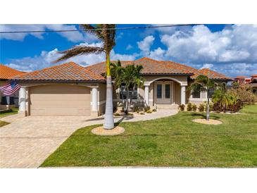 Beautiful two-story home with tile roof, lush landscaping and paved driveway at 2736 Magdalina Dr, Punta Gorda, FL 33950