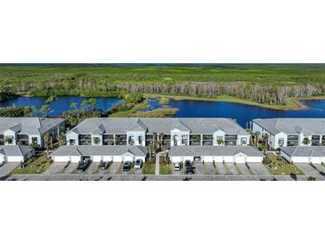 Aerial view of a row of townhouses with attached garages near a lake at 14271 Heritage Landing Blvd # 1526, Punta Gorda, FL 33955