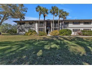 Two-story condo building with palm trees and a lush lawn at 1515 Forrest Nelson Blvd # H204, Port Charlotte, FL 33952