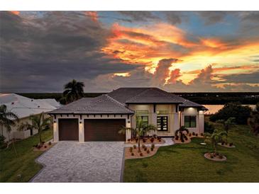 Luxury waterfront home with a three-car garage and scenic sunset views at 5179 Collingswood Blvd, Port Charlotte, FL 33948