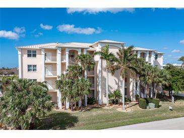 Three story building with palm trees and landscaping at 268 Lewis Cir # 132, Punta Gorda, FL 33950