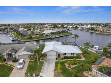 Waterfront home with canal access, lush landscaping, and a two-car garage at 1230 Swan Ct, Punta Gorda, FL 33950