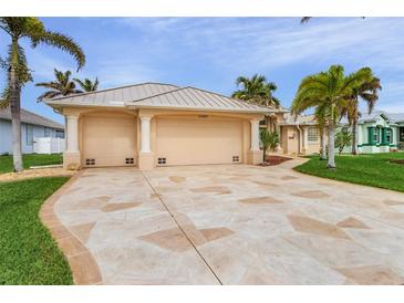 Tan two-story house with a two-car garage and landscaped yard at 15460 Longview Rd, Port Charlotte, FL 33981
