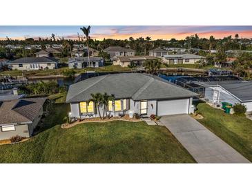 Charming waterfront home with lush lawn, mature trees, and a two-car garage at 3225 Magnolia Way, Punta Gorda, FL 33950