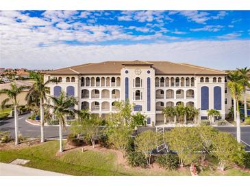 Attractive three-story building with palm trees and landscaping at 1349 Aqui Esta Dr # 125, Punta Gorda, FL 33950