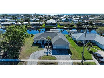 Aerial view of a single-Gathering home with a paver driveway and canal access at 21341 Edgewater Dr, Port Charlotte, FL 33952