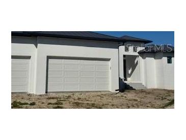 Three-car garage and front entrance of a new construction home at 24092 Potosi Ct, Punta Gorda, FL 33955