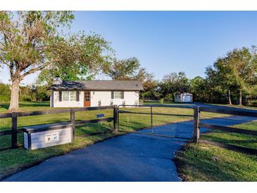 Charming home exterior with a long driveway and a rustic fence at 1010 Robinhood Dr, Punta Gorda, FL 33982
