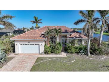 Single-story home with tile roof, attached garage, and landscaped yard at 24282 Silver Ln, Punta Gorda, FL 33955