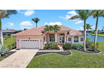 Inviting single-story home with a red tile roof, well-manicured lawn, and lush tropical landscaping at 24282 Silver Ln, Punta Gorda, FL 33955