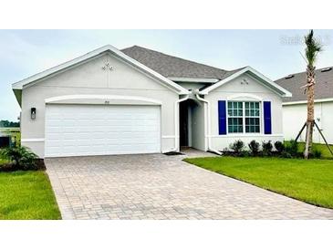 Charming single-story home showcasing a paved driveway, well-manicured lawn, and neutral-tone facade at 9531 Turtle Grass Cir, Punta Gorda, FL 33950
