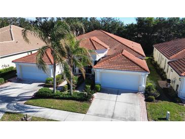 Attractive single-Gathering home with two-car garage, lush landscaping, and a tile roof at 10900 Lerwick Cir, Englewood, FL 34223