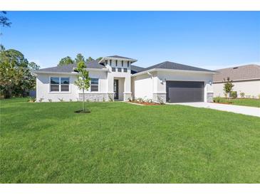 One-story home with gray roof, white siding, and stone accents at 2219 Arnet St, Port Charlotte, FL 33948