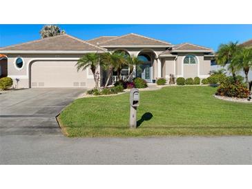 Attractive single-story home with a well-manicured lawn and attached garage at 566 Port Bendres Dr, Punta Gorda, FL 33950