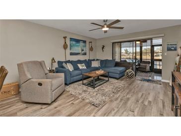 Inviting living room with a cozy blue sectional, neutral decor, and access to a sunroom at 240 Lewis Cir # 29, Punta Gorda, FL 33950