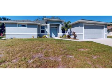 Single-story home with gray exterior, attached garage, and landscaped lawn at 3087 Eagle Pass St, North Port, FL 34286