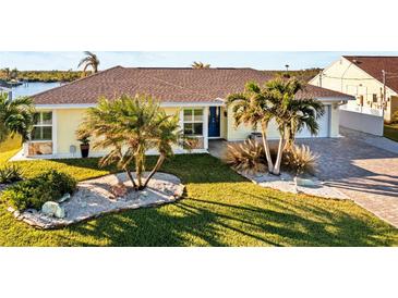 Beautiful waterfront home with a landscaped yard and paver driveway at 4195 Surfside Ct, Port Charlotte, FL 33948