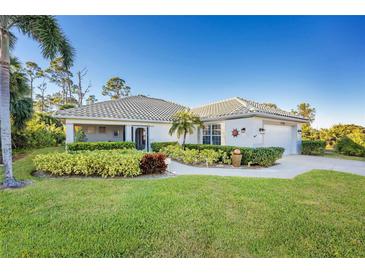 Single-story home with tile roof, landscaped yard, and driveway at 17513 Pomegrante Way, Punta Gorda, FL 33955