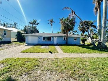 Light blue single story home with attached garage and palm trees at 201 Mcgregor St, Punta Gorda, FL 33950