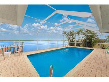 Refreshing screened pool overlooking the water at 3220 Peace River Dr, Punta Gorda, FL 33983