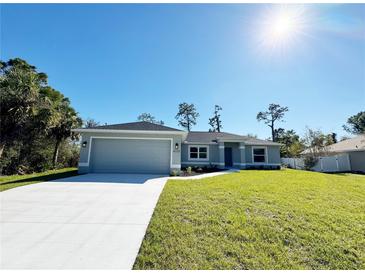 Gray house with a two-car garage and a well-maintained lawn at 4232 Fernway Dr, North Port, FL 34288